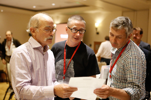 Arthur Toga of the USC Stevens Neuroimaging and Informatics Institute and USC Stem Cell’s Andrew McMahon check an agenda with Raymond Stevens of the Bridge Institute at USC Dornsife. (Photo by Steve Cohn)