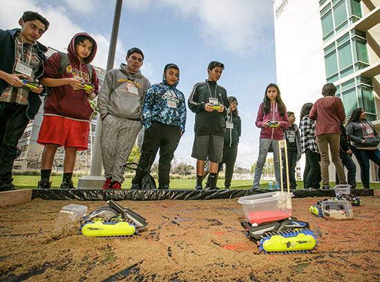 Students drive remote control trucks while learning about bone repair. (Photo by David Sprague)