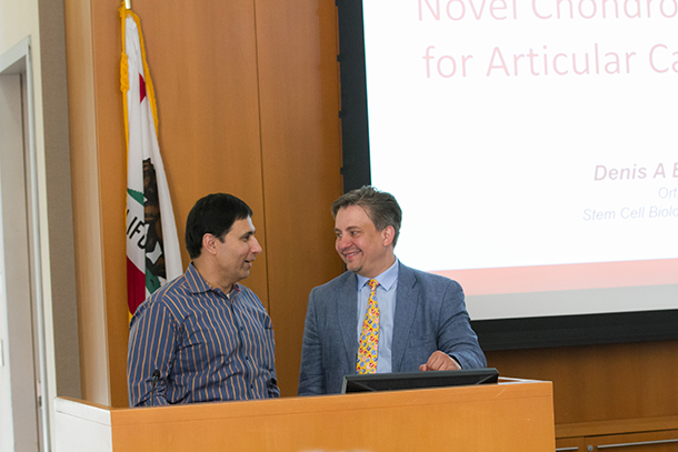Mark Humayun, left, talks to Denis Evseenko, right, before Evseenko gives a presentation during a Feb. 7 celebration of pilot funding programs at the Keck School of Medicine of USC. (Photo by Ricardo Carrasco III)