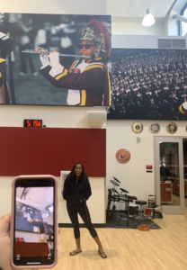 Tiffany Mays being photographed in front of a photo of herself in the Trojan Marching Band office (Photo by Marisa Fuse)